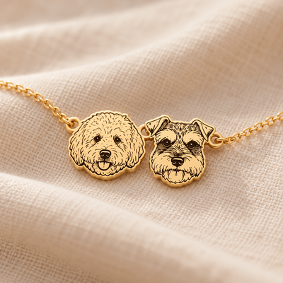 Close-up of the flat engraved dog portrait charms on the golden bracelet